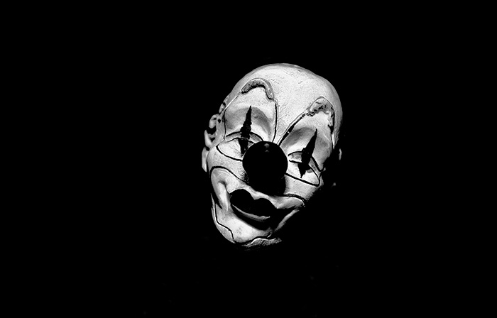 Tilted clown face surrounded by black negative space