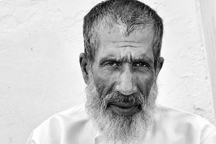 OMA0349BW15X10 Portrait of an elderly Omani man staring intently at the camera