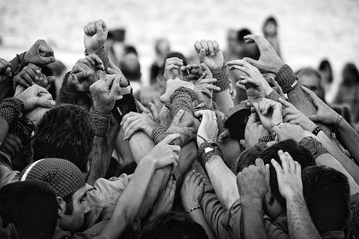 SPA0079BW15X10P Head and shoulder shot of a group of people linking arms above their head