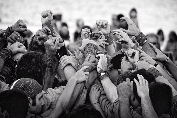 Head and shoulder shot of a group of people linking arms above their head