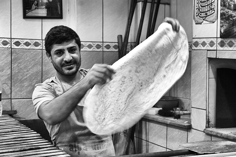 TUR0054BW15X10 A pide (Turkish pizza) chef stretches the dough