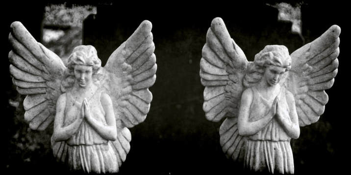 Graveyard Statues of two praying angels standing alongside each other