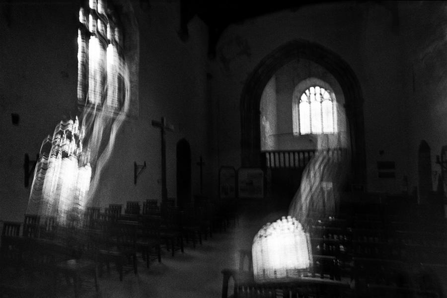 Dark interior of an ancient church with blurred light streaks entering through the windows