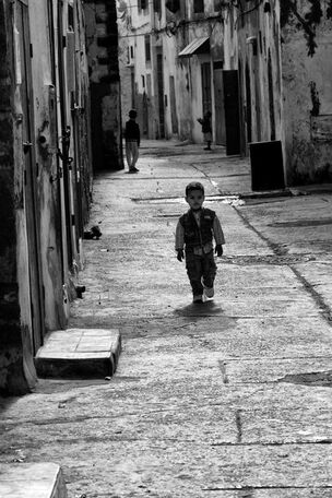 A young boy walks toward the photographer in a Moroccan medina