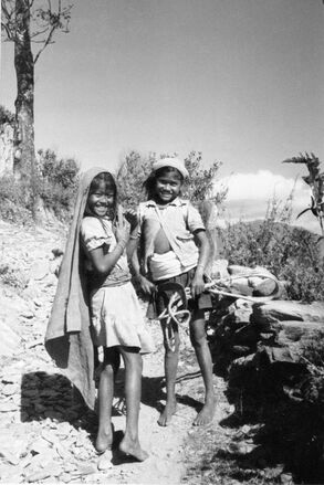 nep00001 Two local girls pose for a photograph on a Himalayan hillside in Nepal