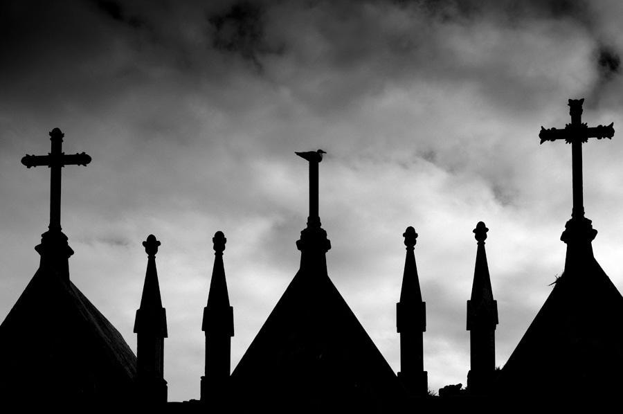 Silhouettes of church spires against a moody sky