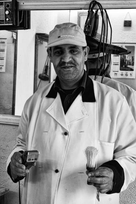 tun0033bw10x15 A barber in the Tunisian city of Sousse shows off the tools of his trade