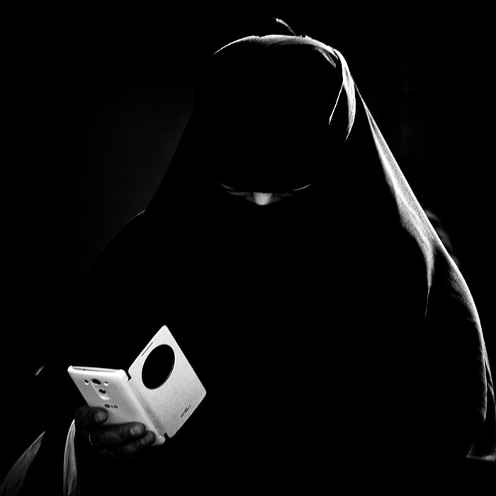 tur0023bw6x6_orig Candid portrait of a woman dressed in a niqab having a Facetime conversation